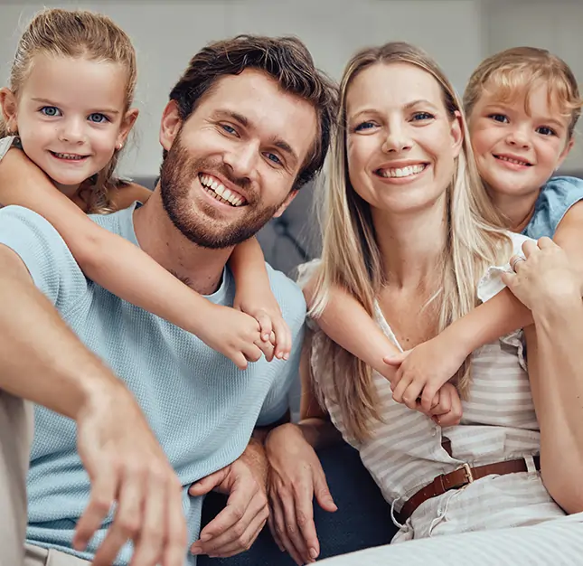 Happy family of four smiling together indoors at dental office