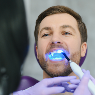 Patient receiving teeth whitening treatment from a dentist in peoria